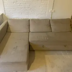 Sofá seccional beige con manchas, ideal para aprender como quitar manchas de chocolate del sofá.