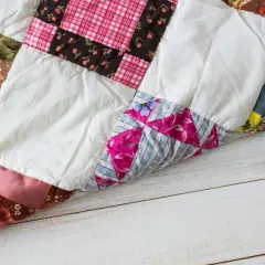 Colchas patchwork fáciles de hacer, con retazos de tela de flores, cuadros y rayas, sobre una mesa de madera.