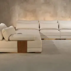 Sofá modular beige con cojines mullidos, detalles de madera y una textura que evoca nombres de telas como lino o algodón.