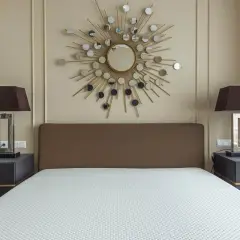 Un espejo sol y lámparas oscuras iluminan la habitación, demostrando como alegrar una habitación con muebles oscuros.