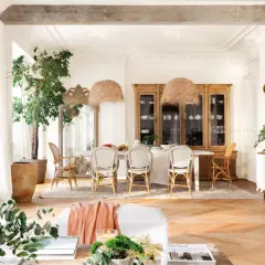 Elegante comedor con suelo de roble en espiga. Muebles de madera clara y mimbre combinan a la perfección, creando un ambiente cálido y acogedor.