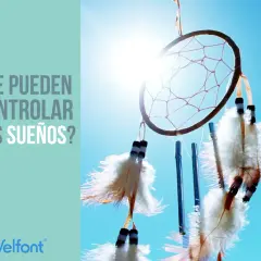 Atrapasueños con plumas flotando contra un cielo azul brillante, invitando a reflexionar sobre como controlar los sueños.