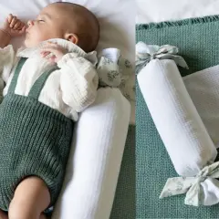Bebé durmiendo plácidamente, rodeado de protectores para hacer colecho. Un nido seguro y acogedor.