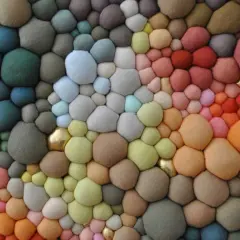 Textura orgánica de burbujas de **fibras sintéticas** en degradado de colores, con toques dorados.