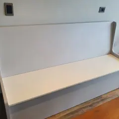 Un banco moderno con respaldo alto, listo para tapizar. Perfecto para añadir comodidad y estilo a cualquier espacio.