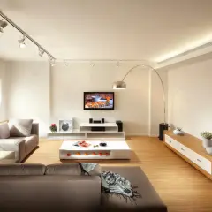 Iluminación moderna: cómo distribuir focos en el techo para crear ambiente en un salón con sofás, TV y mesa de centro.