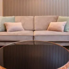 Sofá beige con cojines pastel. Aprende como limpiar un sofa antimanchas para mantenerlo impecable.