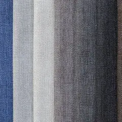 Muestrario de diferentes tipos de tela en tonos azules, grises y marrones, con texturas visibles.