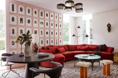 Un sofá rojo vibrante es el centro de atención en esta sala de estar moderna. Descubre cómo combinar un sofá rojo con arte abstracto y mobiliario ecléctico.