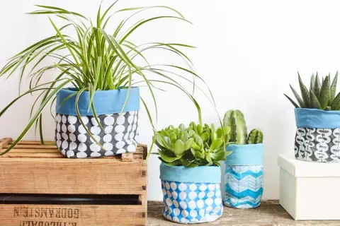 Maceteros decorados con tela de saco, con plantas de interior y suculentas.