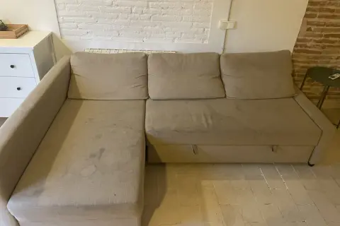 Sofá seccional beige con manchas, ideal para aprender como quitar manchas de chocolate del sofá.
