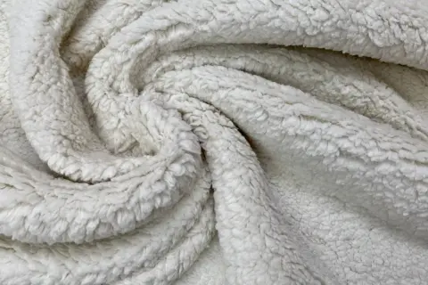 Textura suave y esponjosa de que es la felpa, ideal para mantas acogedoras.