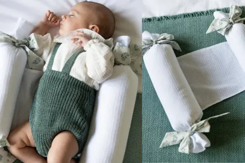 Bebé durmiendo plácidamente, rodeado de protectores para hacer colecho. Un nido seguro y acogedor.