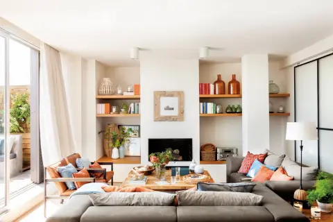 Ideas para cómo distribuir un salón comedor cuadrado: sofás modulares, mesa de centro de madera y estanterías con decoración.