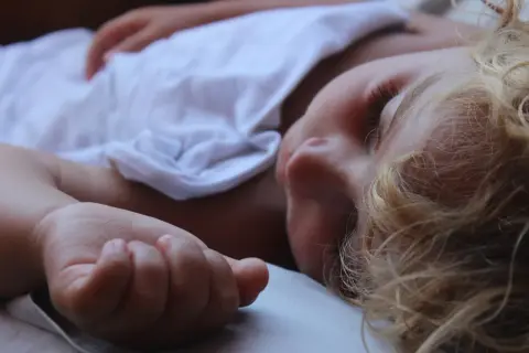 Niño rubio de 12 años durmiendo plácidamente, ajeno a cualquier posible sonambulismo nocturno.