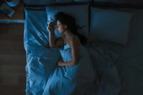 Mujer durmiendo plácidamente, buscando cómo dormir con calor y sin aire acondicionado.