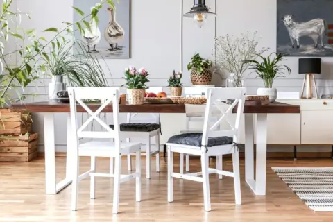 Comedor con mesa de madera oscura y sillas blancas, un ejemplo perfecto de cómo combinar muebles blancos y madera oscura para un estilo acogedor.
