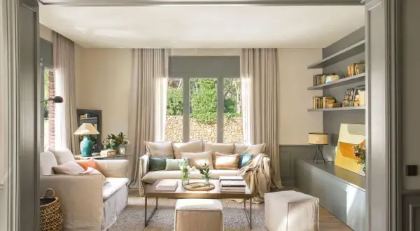 Salones beige y gris con sofás cómodos, mesa de centro de madera y estanterías llenas de libros.