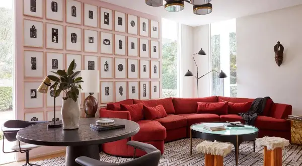 Un sofá rojo vibrante es el centro de atención en esta sala de estar moderna. Descubre cómo combinar un sofá rojo con arte abstracto y mobiliario ecléctico.