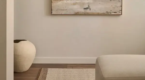Ideas para decorar un pasillo: un jarrón grande y una alfombra geométrica bajo un cuadro abstracto.
