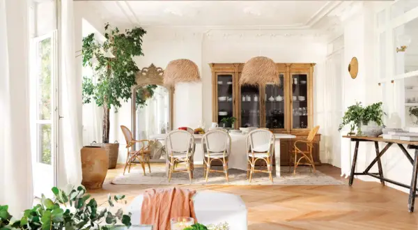 Elegante comedor con suelo de roble en espiga. Muebles de madera clara y mimbre combinan a la perfección, creando un ambiente cálido y acogedor.