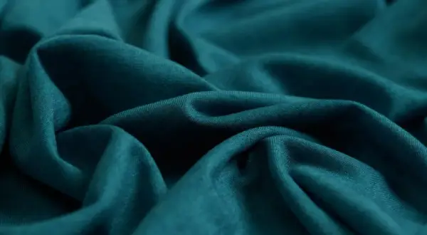 Tejido de punto azul verdoso, suave y fluido. Ideal para saber qué tejido es más fresco para el verano.