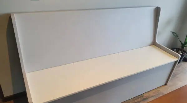 Un banco moderno con respaldo alto, listo para tapizar. Perfecto para añadir comodidad y estilo a cualquier espacio.