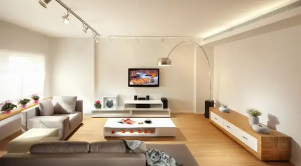 Iluminación moderna: cómo distribuir focos en el techo para crear ambiente en un salón con sofás, TV y mesa de centro.