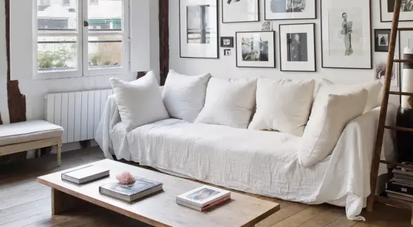 Sofá cheslong blanco con cojines mullidos, perfecto para saber como colocar cojines en un sofa cheslong y crear un rincón acogedor.
