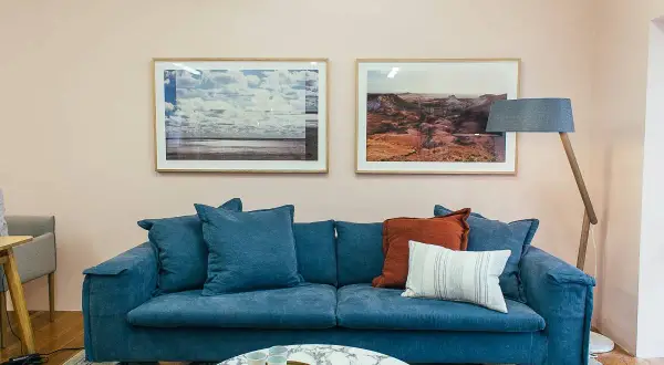 Sofá azul profundo con cojines que combinan a la perfección, creando un rincón acogedor.