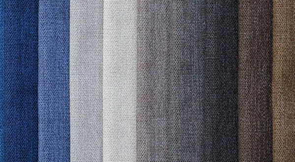 Muestrario de diferentes tipos de tela en tonos azules, grises y marrones, con texturas visibles.