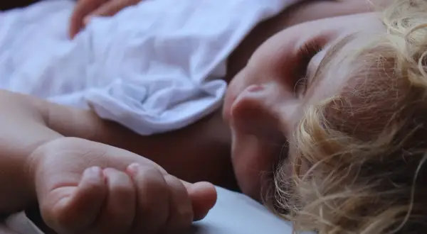 Niño rubio de 12 años durmiendo plácidamente, ajeno a cualquier posible sonambulismo nocturno.