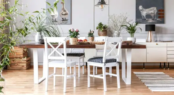 Comedor con mesa de madera oscura y sillas blancas, un ejemplo perfecto de cómo combinar muebles blancos y madera oscura para un estilo acogedor.