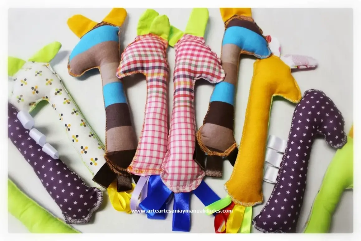 Manualidades de costura para el hogar: jirafas de tela de colores, algunas con cintas y estampados, perfectas para decorar o regalar.