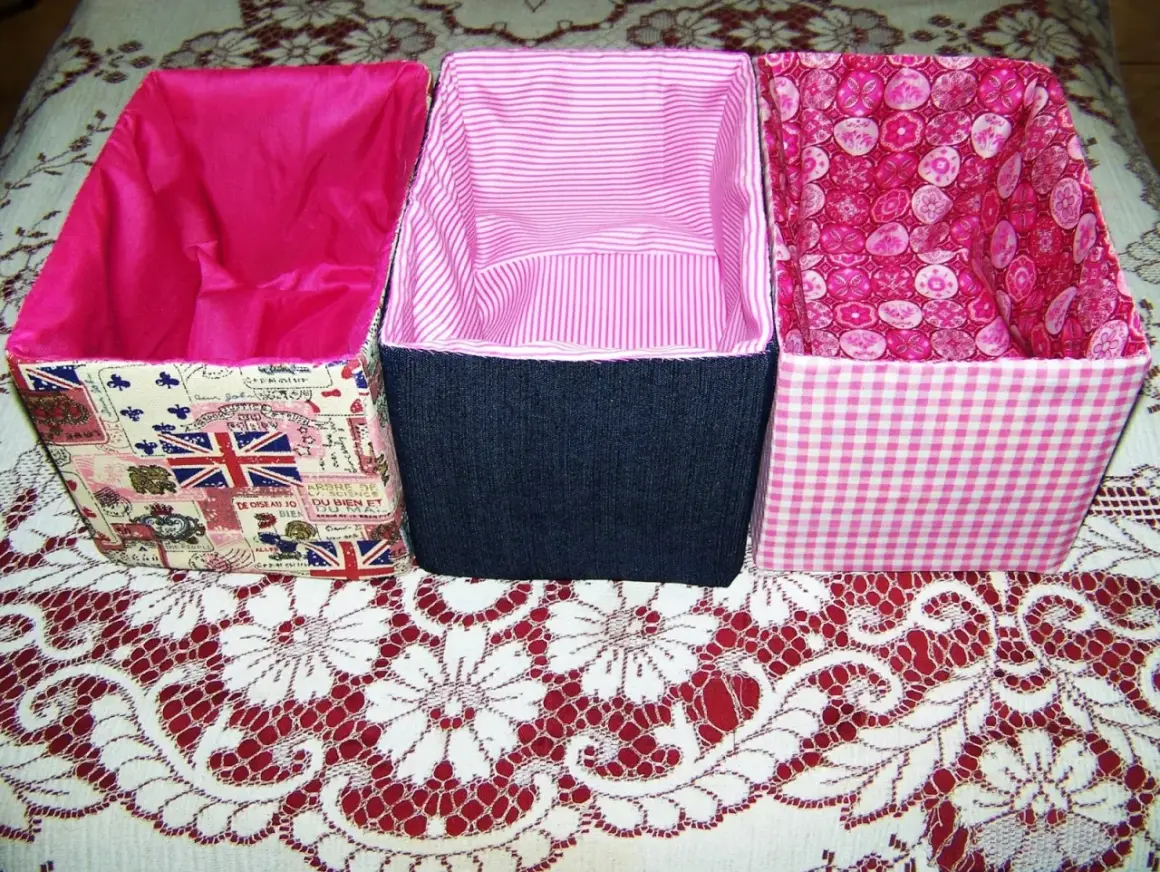 Cajas forradas con tela: una con estampado de Union Jack, otra de mezclilla azul y la tercera con cuadros rosas.