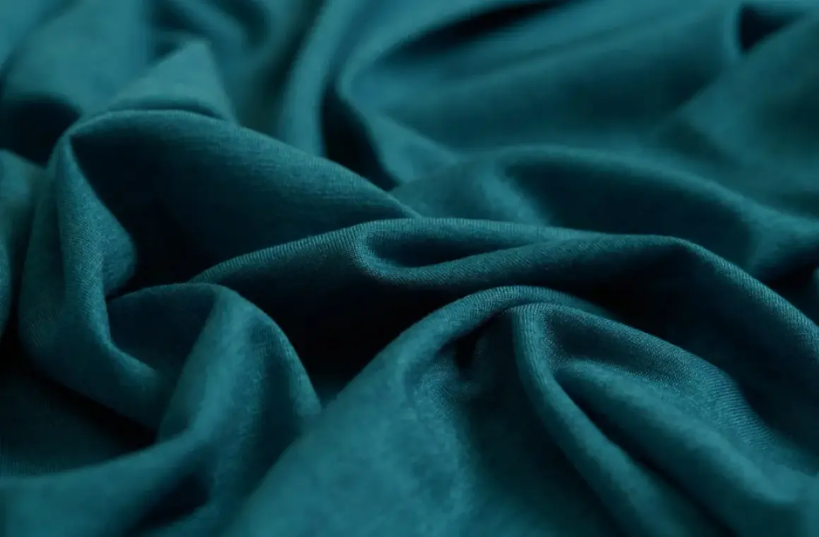 Tejido de punto azul verdoso, suave y fluido. Ideal para saber qué tejido es más fresco para el verano.