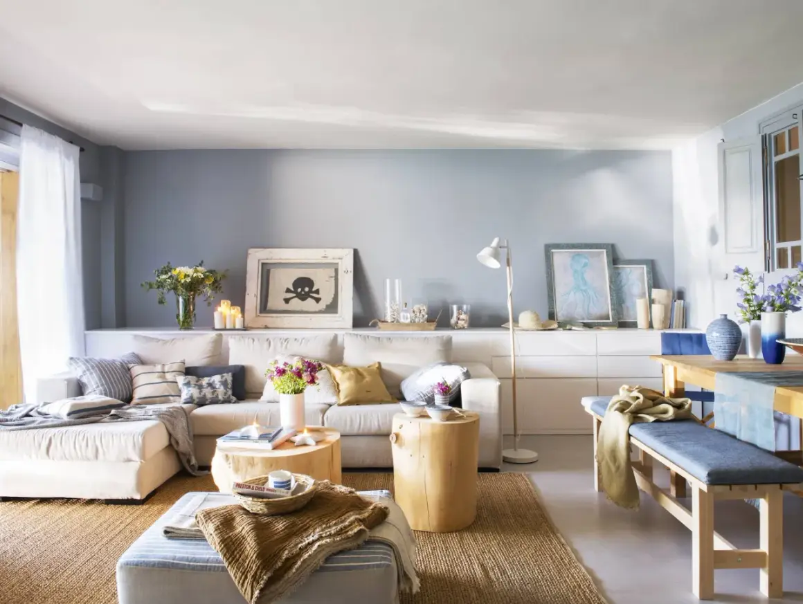 Sofá beige y cojines azules crean un ambiente acogedor. Tonos tierra y marinos se combinan en esta sala.