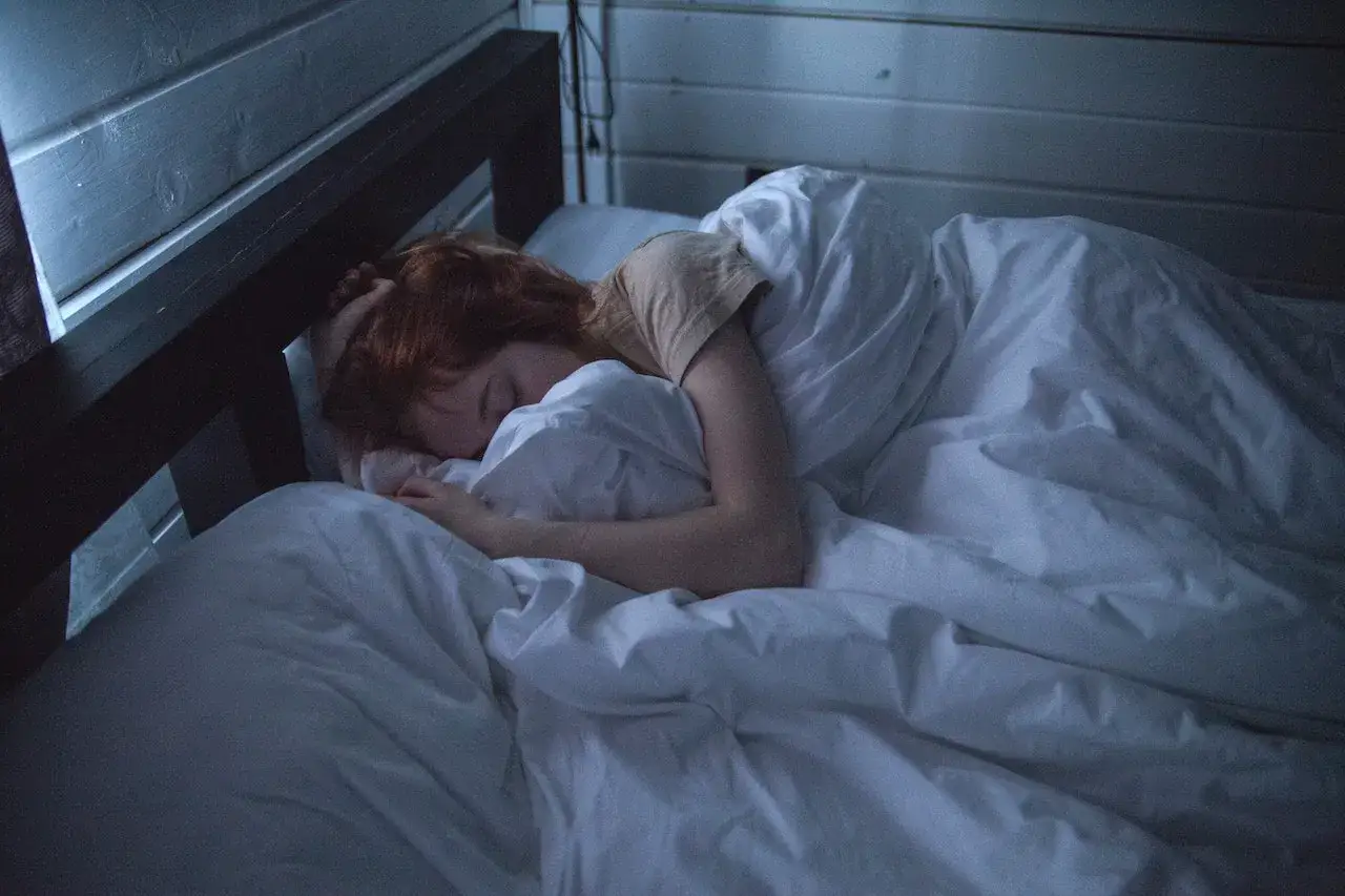 Una persona duerme acurrucada bajo las s&aacute;banas. La somnifobia es el miedo a dormir, pero aqu&iacute;, el sue&ntilde;o parece un refugio.