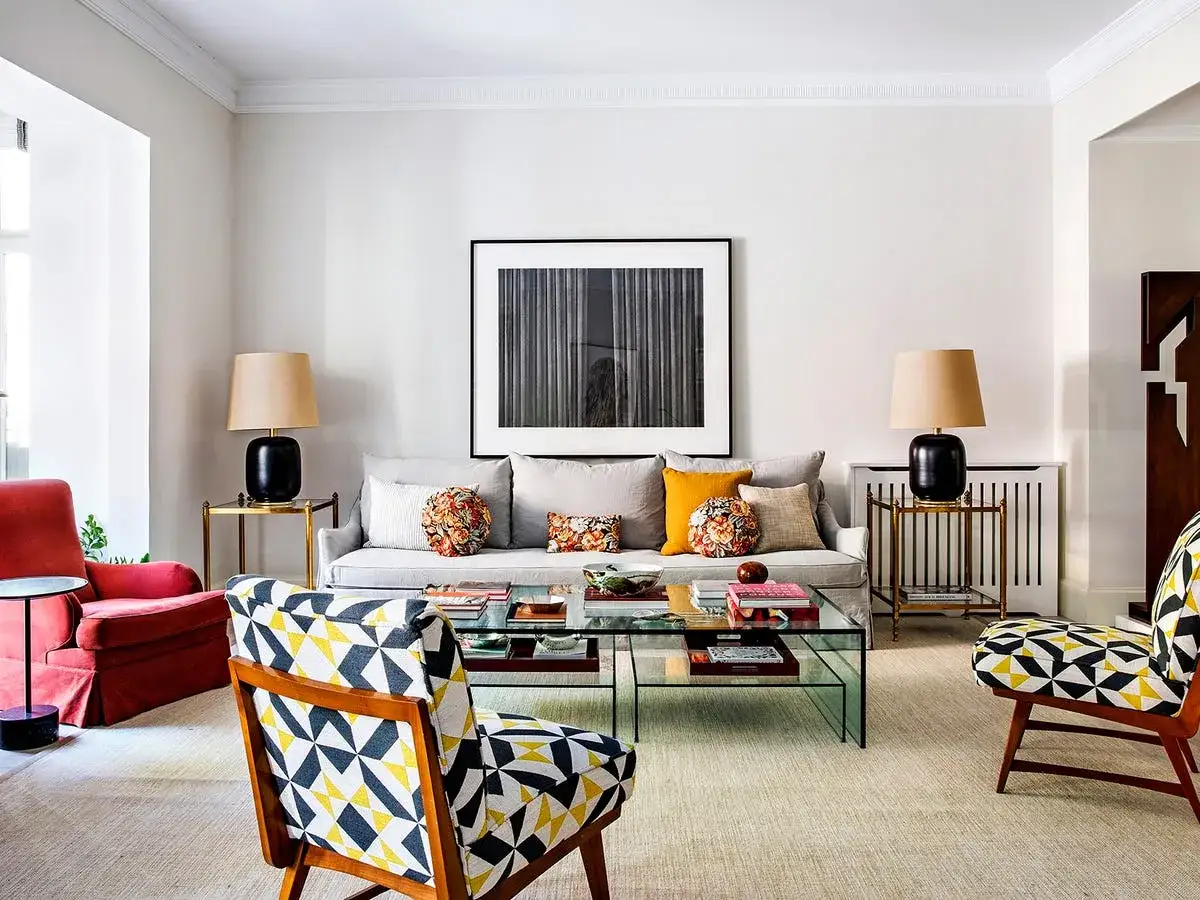 Sof&aacute; gris, butaca roja y sillones con estampado geom&eacute;trico. La diferencia entre butaca y sill&oacute;n se aprecia en su dise&ntilde;o y tama&ntilde;o.