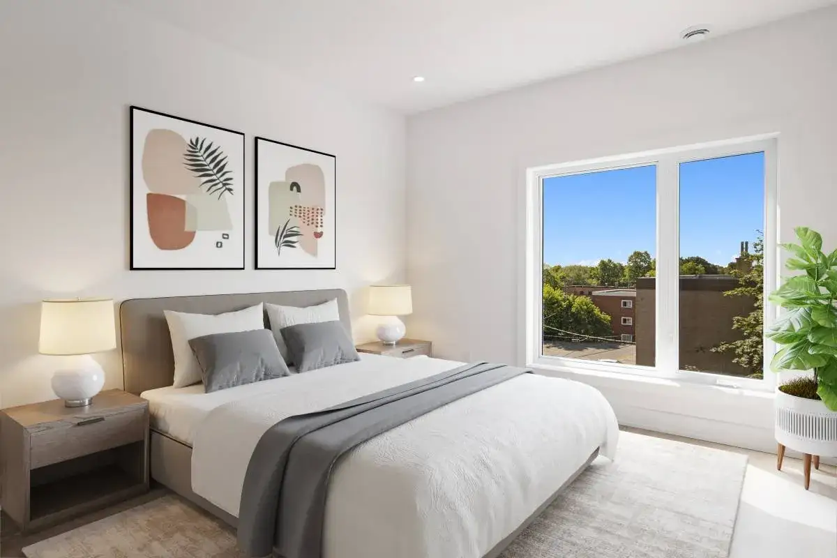 Dormitorio moderno con cama canapé vestida con ropa de cama blanca y gris, mesitas de noche y cuadros abstractos.