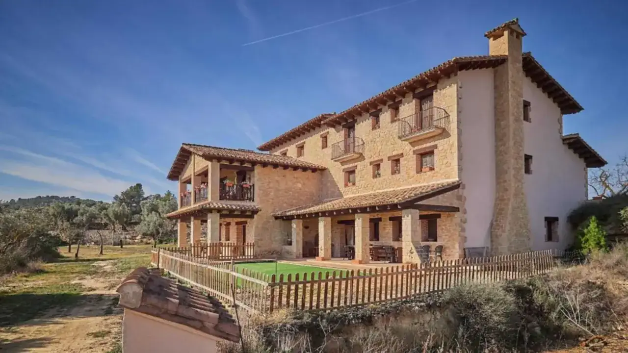Casa de pueblo con encanto, ideal para decorar con poco dinero. Fachada de piedra, balcones y un jard&iacute;n acogedor.