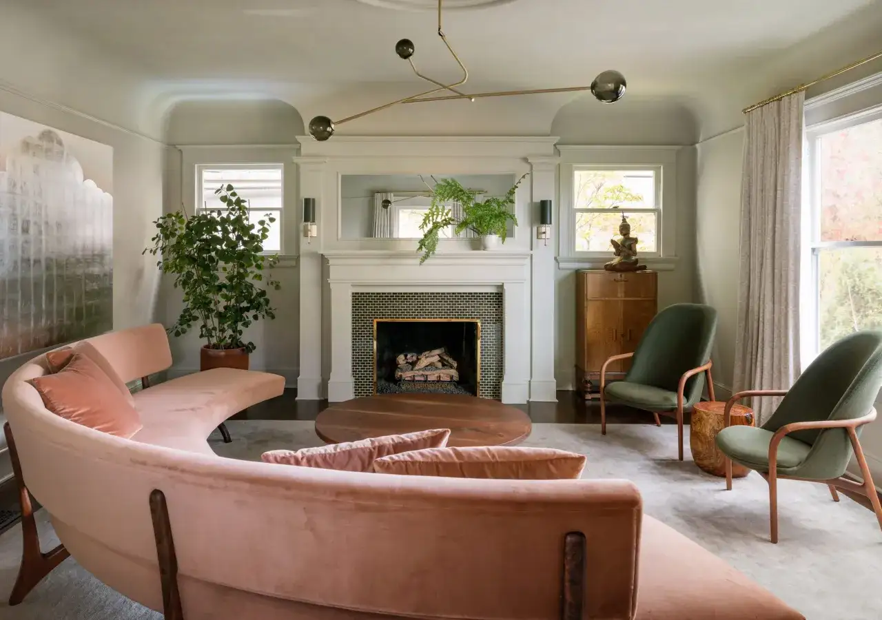 Sofá curvo rosa palo y sillones verdes crean un ambiente acogedor. La combinación de rojo y rosa palo en la decoración es sutil y elegante.