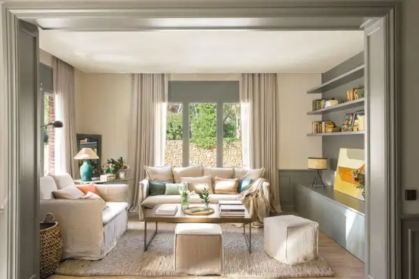 Salones beige y gris con sofás cómodos, mesa de centro de madera y estanterías llenas de libros.
