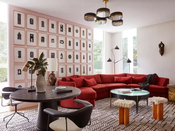 Un sofá rojo vibrante es el centro de atención en esta sala de estar moderna. Descubre cómo combinar un sofá rojo con arte abstracto y mobiliario ecléctico.