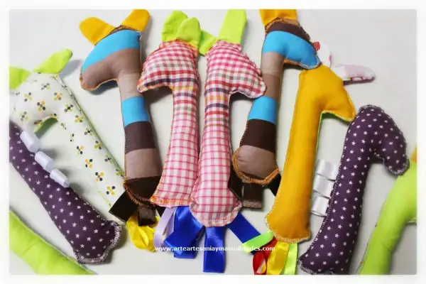 Manualidades de costura para el hogar: jirafas de tela de colores, algunas con cintas y estampados, perfectas para decorar o regalar.