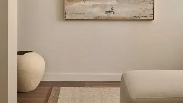 Ideas para decorar un pasillo: un jarrón grande y una alfombra geométrica bajo un cuadro abstracto.