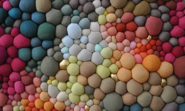 Textura orgánica de burbujas de **fibras sintéticas** en degradado de colores, con toques dorados.