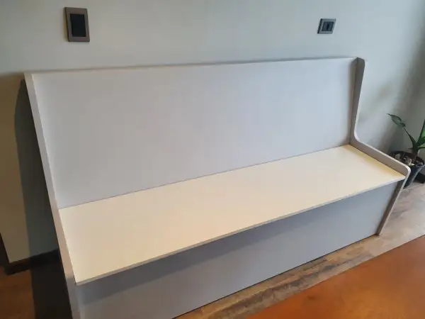 Un banco moderno con respaldo alto, listo para tapizar. Perfecto para añadir comodidad y estilo a cualquier espacio.