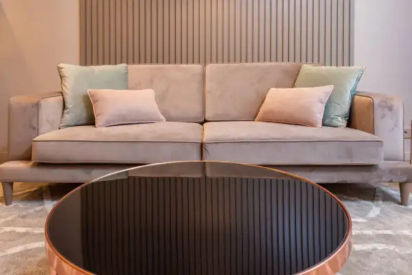 Sofá beige con cojines pastel. Aprende como limpiar un sofa antimanchas para mantenerlo impecable.