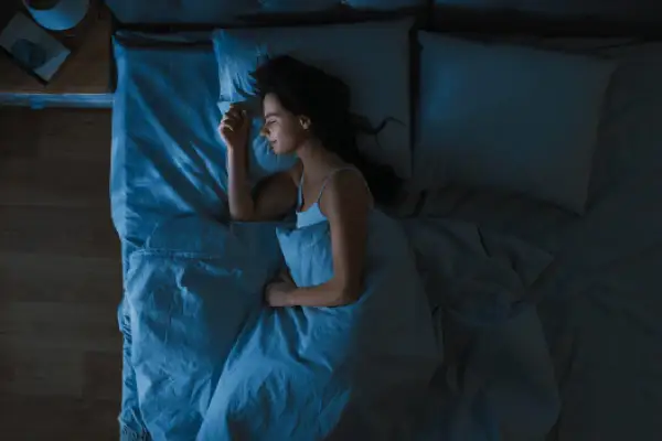 Mujer durmiendo plácidamente, buscando cómo dormir con calor y sin aire acondicionado.